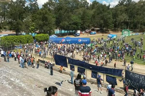 Aficionados ingresan a la gramilla para resguardarse. (Foto Prensa Libre: Eduardo González)