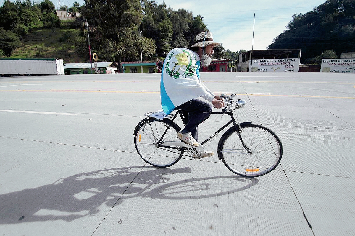 Con la bandera de Guatemala un sombrero de paja y subido en su bicicleta Ochoa retomó la marcha rumbo a la capital. (Foto Prensa Libre: Erick Ávila)