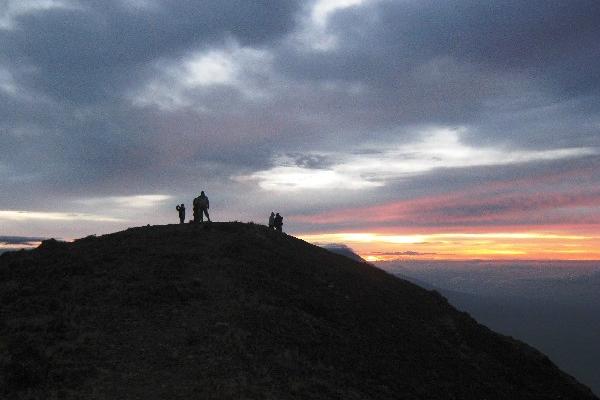 un Grupo  de escaladores disfruta del atardecer en la cumbre del Volcán Atitlán.