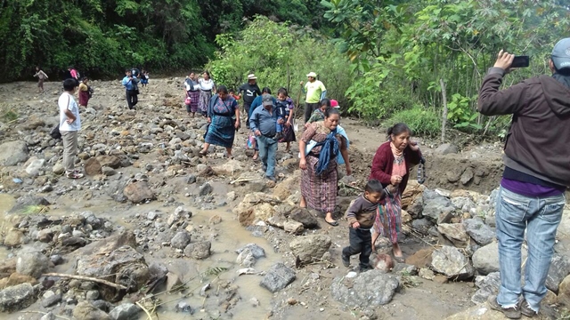 Varias personas caminan en el área del derrumbe de la ruta en el cerro Lec. (Foto Prensa Libre: Ángel Julajuj)