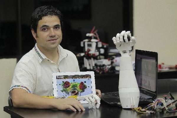 Alí Lemus, muestra dos de sus recientes investigaciones, el videojuego   Cerebrex y Bionic Robohand (Foto Prensa Libre: Álvaro Interiano)