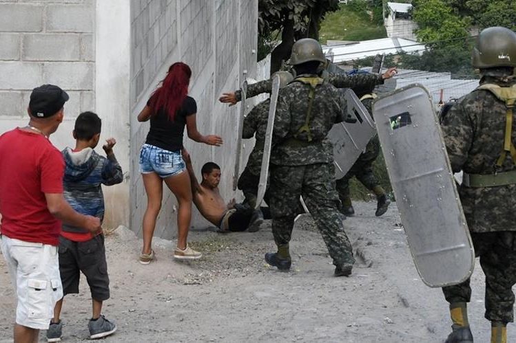 Soldados intentan arrestar a un manifestante, cuando opositores volvieron a salir a las calles en rechazo a las elecciones en Honduras. (Foto Prensa Libre: AFP)