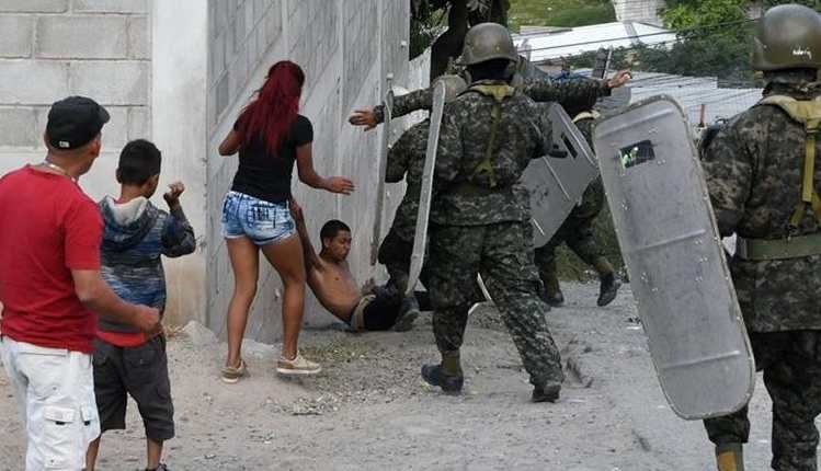 Soldados intentan arrestar a un manifestante, cuando opositores volvieron a salir a las calles en rechazo a las elecciones en Honduras. (Foto Prensa Libre: AFP)