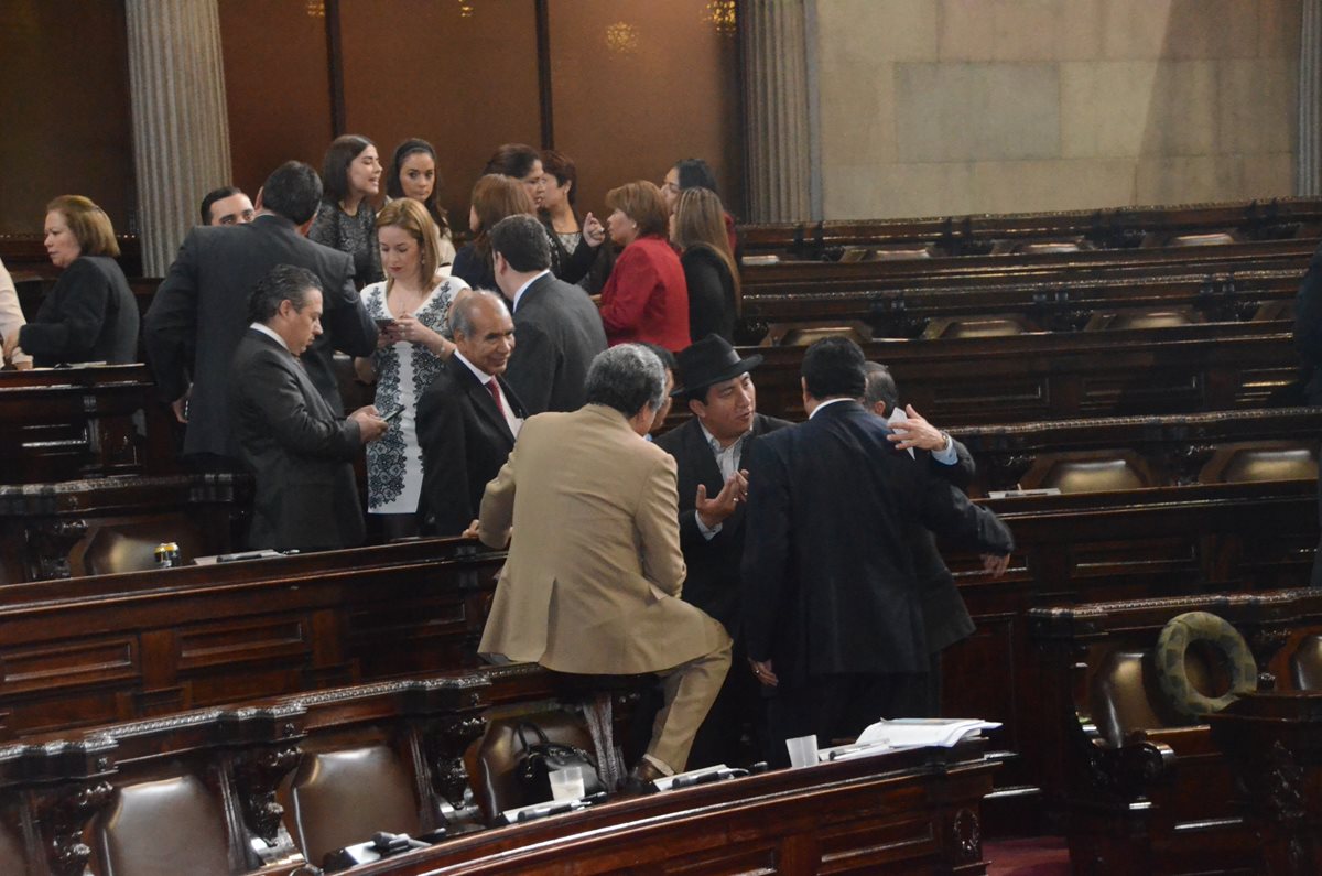 El diputado Wálter Félix, de la URNG, se sienta en el respaldo de las curules y pone un pie en un descansabrazos. (Foto Prensa Libre)