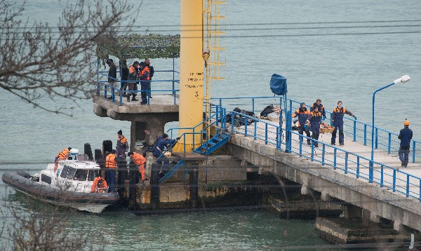 Rescatistas trasladan fragmentos y restos encontrados en el lugar del accidente aéreo. (Foto Prensa Libre: EFE)