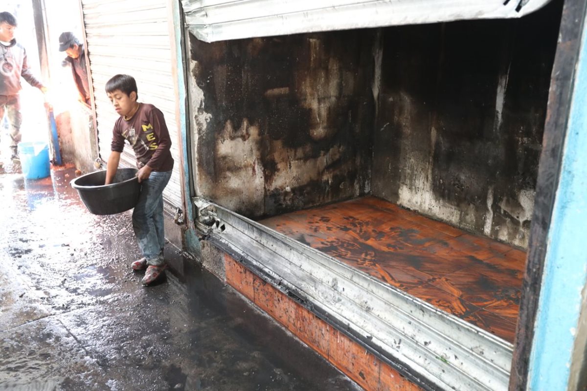 Inquilinos del mercado de Villa Canales apoyaron en los trabajos de limpieza luego del incendio que consumió seis locales este 25 de diciembre. (Foto Prensa Libre: Esbin García)
