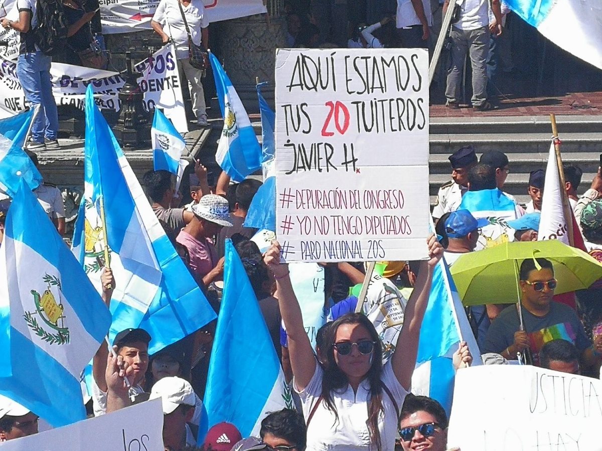 Guatemalteca muestra cartel con mensaje para el Congreso. (Foto Prensa Libre: Estuardo Paredes)