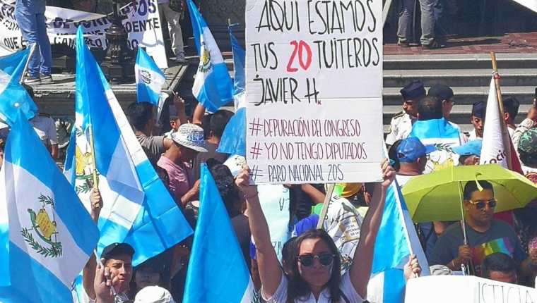 Guatemalteca muestra cartel con mensaje para el Congreso. (Foto Prensa Libre: Estuardo Paredes)
