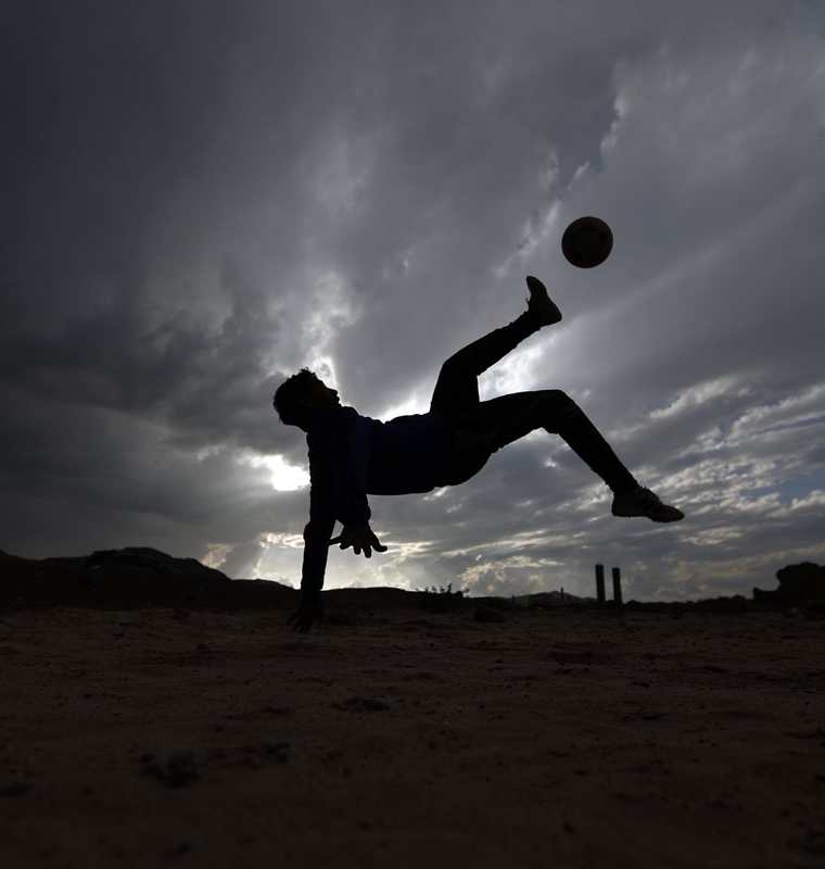 Un joven Yemeni patea el balón durante un juego de barrio con sus amigos en Sanaa. (Foto Prensa Libre: AFP)