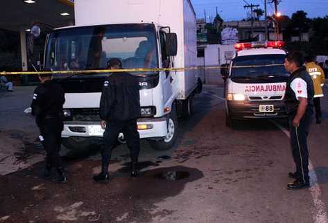 Agentes de la Policía Nacional Civil revisan el camión donde murió el guardia Alfonso Ical en Sumpango. (Foto Prensa Libre: Víctor Chamalé).