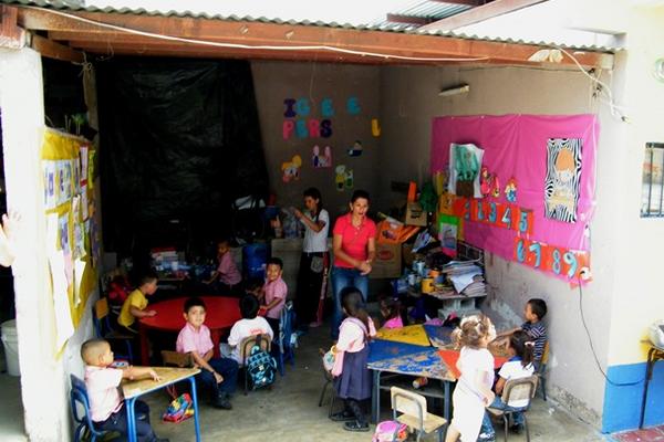 Esta aula  no tiene pared, por lo que la maestra debe estar pendiente de  que los niños no salgan o se vayan a jugar a una pila que está cerca,  pues puede ocurrir una tragedia. (Foto Prensa Libre: Héctor Contreras)