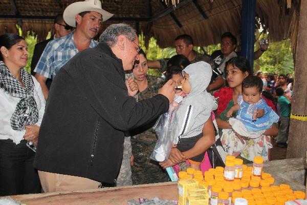 El embajador Arnold Chacón  suministra una dosis de  desparasitante a un niño  de Camotán.