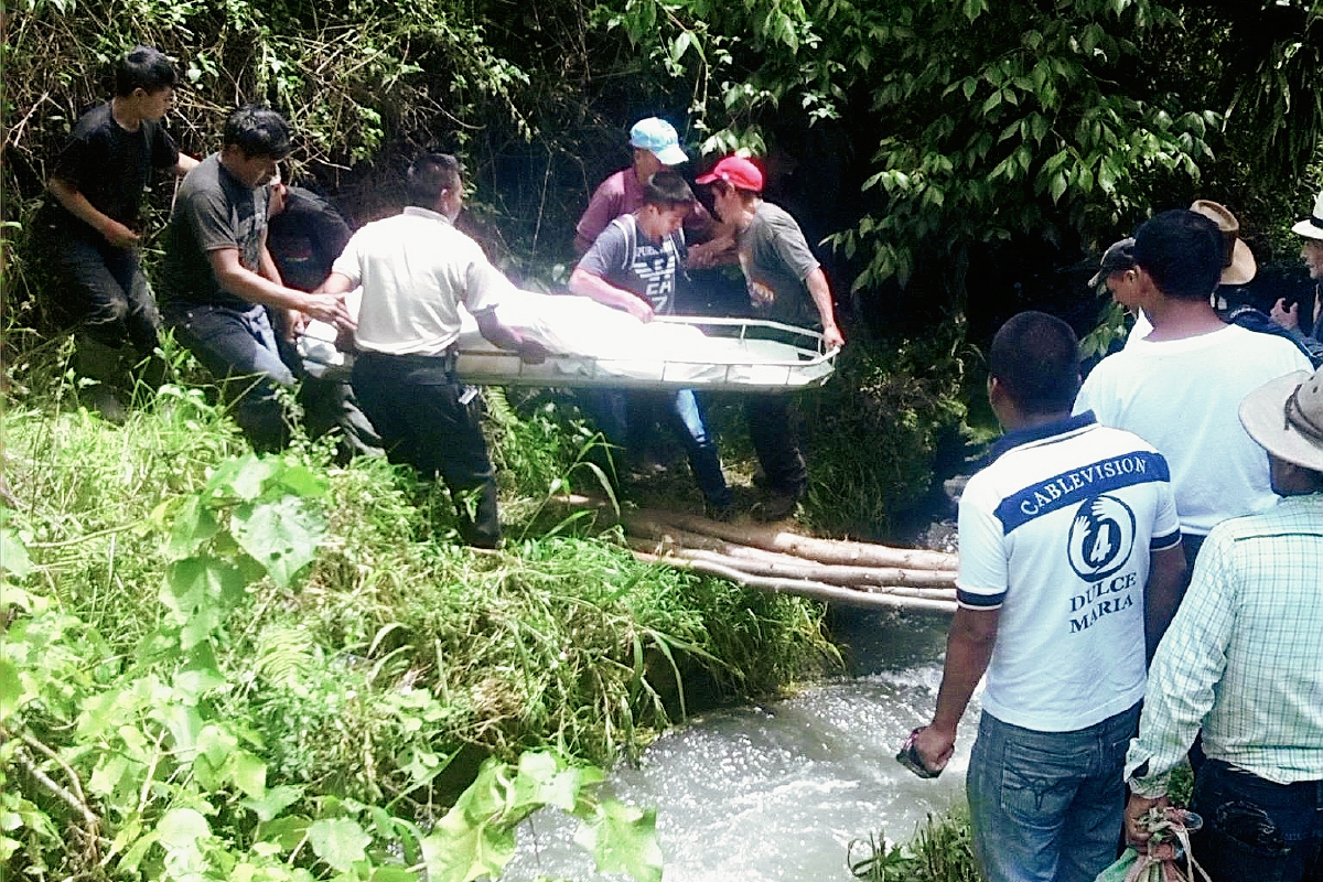 Bomberos  y vecinos   rescatan el cuerpo de la mujer, en Nebaj, Quiché.  (Foto Prensa Libre: Óscar Figueroa)