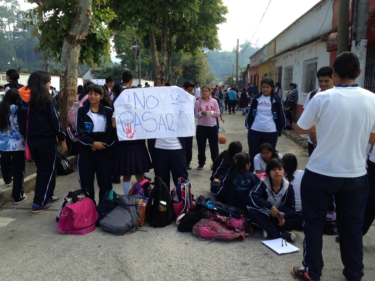 Estudiantes inconformes usaron carteles para dar a conocer el bloqueo de las calles aledañas al l instituto. (Foto Prensa Libre: Eduardo Sam)