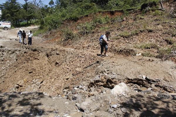 Pobladores pasan por el lugar donde se produjo un deslizamiento, en el kilómetro  95  de la Ruta Nacional 5, entre Santa Cruz El Chol y Rabinal, Baja Verapaz.