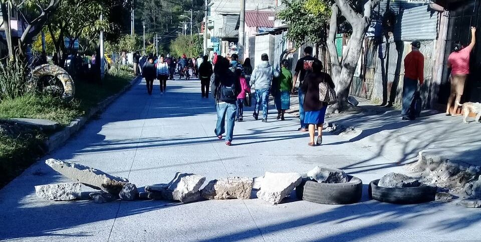 Vecinos de El Búcaro bloquean el paso de vehículos para manifestar contra los hechos de violencia en el sector. (Foto Prensa Libre: Dalia Santos)