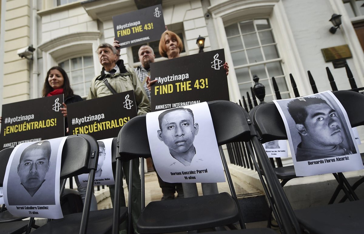 Un grupo de personas protesta frente a al embajada de México en Reino Unido. (Foto Prensa Libre: AFP).