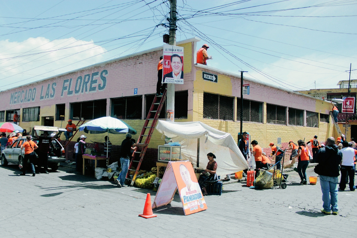 Seguidores de candidatos a la Alcaldía de la ciudad de Quetzaltenango pintan el mercado Las Flores. (Foto Prensa Libre: Carlos Ventura)