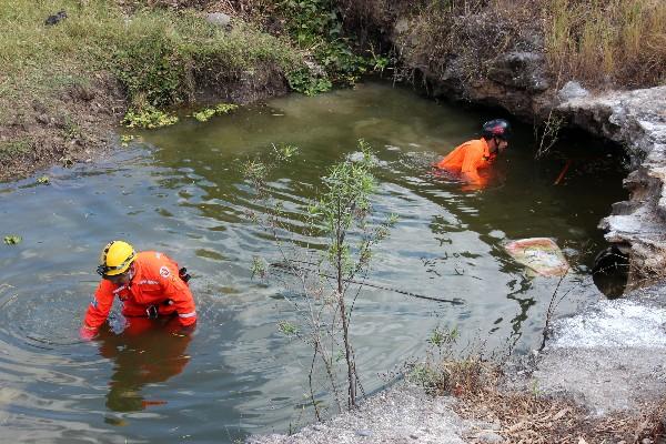 Bomberos Voluntarios buscan   a los dos niños  en una poza  de aguas  servidas.