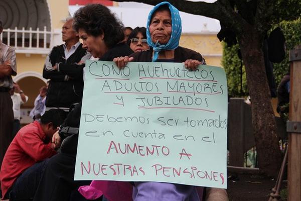 Con pancartas en mano, jubilados llegaron al edificio de gobernación para exigir mejoras en sus pensiones.  (Foto Prensa Libre: Mike Castillo).