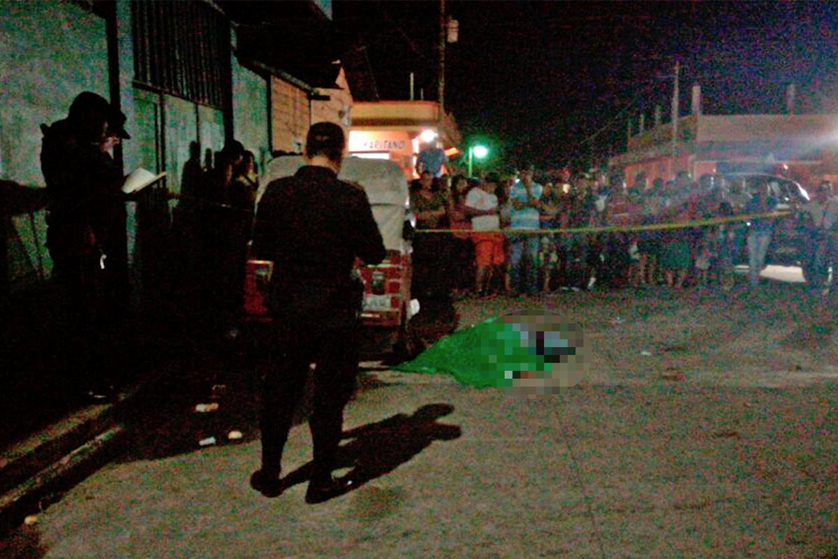 Agentes de la Policía Nacional Civil proceden a cubrir el cadáver de Giancarlo Villagrán Gutiérrez ante la mirada de los vecinos de la zona 2 de Malacatán, San Marcos. (Foto Prensa Libre: Whitmer Barrera).