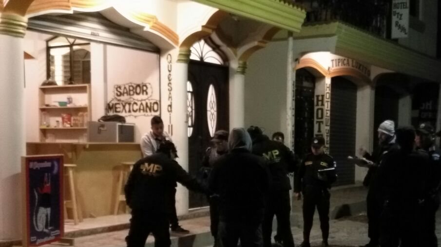 Agentes de la PNC recaban evidencias afuera de una venta de tacos en Panajachel, donde fueron ultimados dos hombres. (Foto Prensa Libre: Ángel Julajuj)
