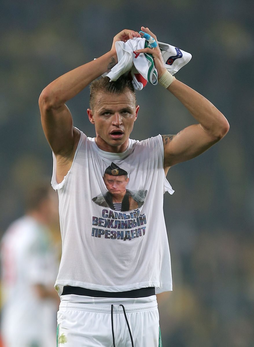 El jugador Dmitry Tarasov muestra camiseta con foto de Putin. (Foto Prensa Libre: AFP)