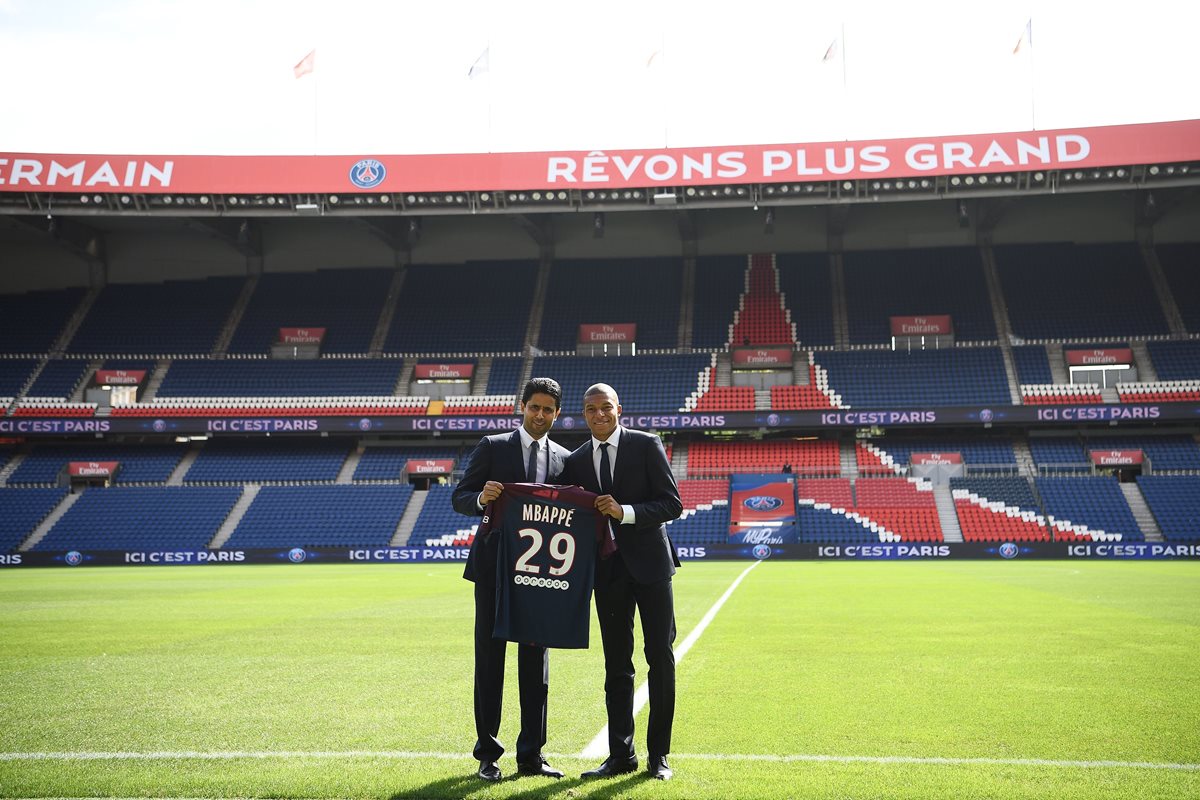 Kylian Mbappé (derecha) posa junto a Nasser Al-Khelaifi, presidente del PSG, durante su presentación en el Parque de los Príncipes. (Foto Prensa Libre: AFP)