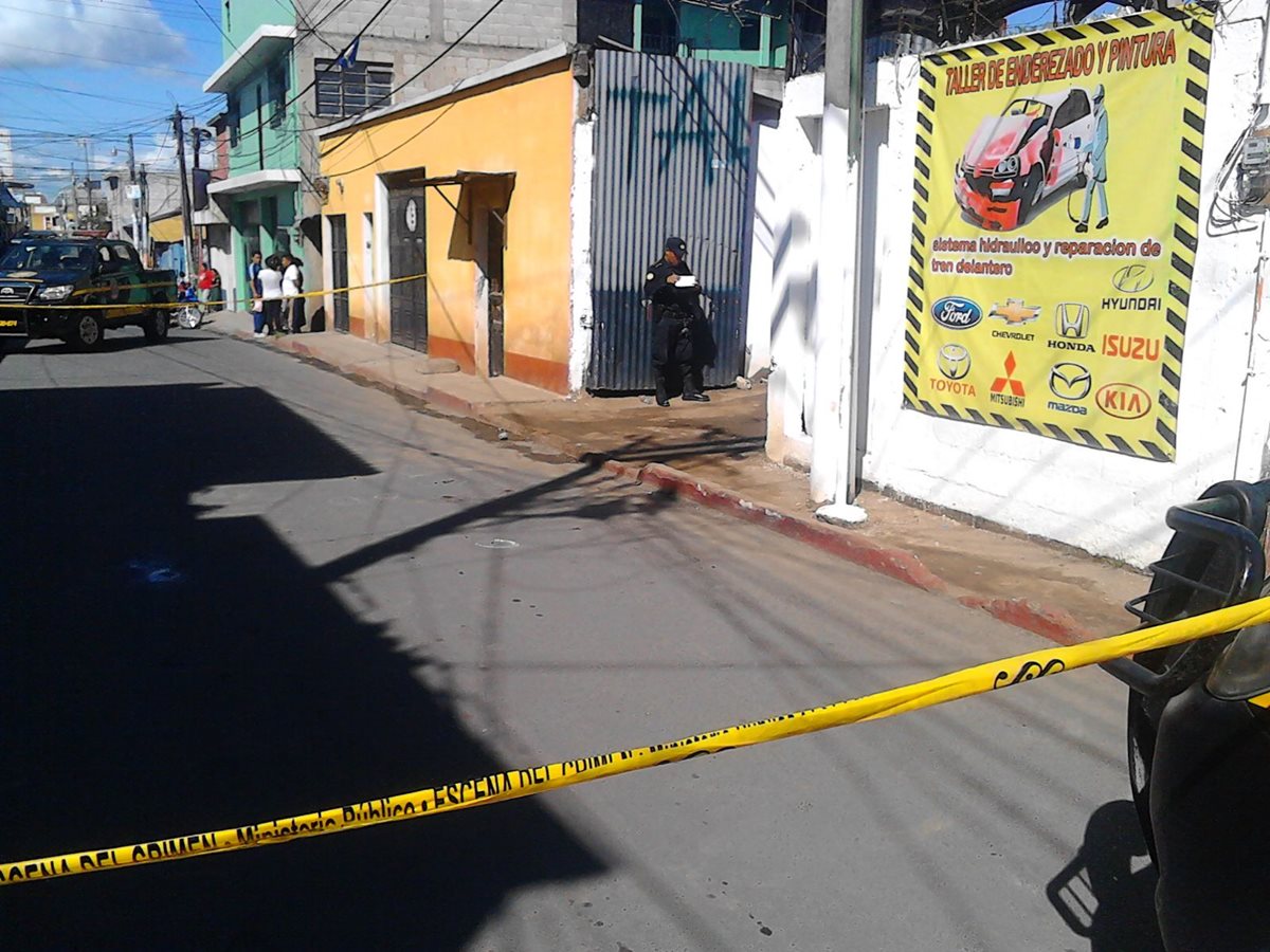 Agentes de la Policía Nacional Civil resguardan taller donde murió a balazos un trabajador, en la zona 1 de la cabecera de Chimaltenango. (Foto Prensa Libre: José Rosales)