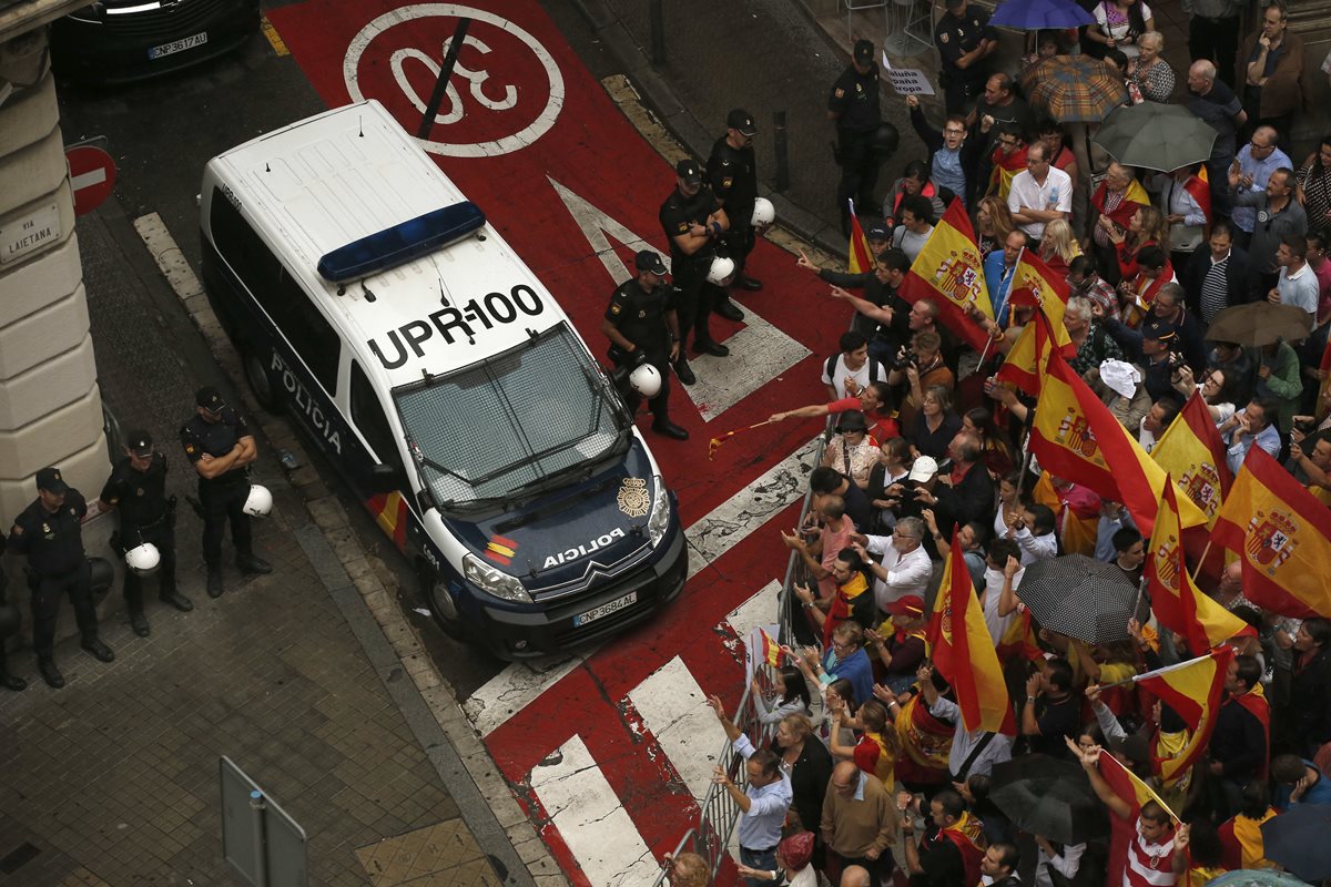 Policías españoles ven a los manifestantes defendiendo la unidad de España y contra un referendo catalán. (Foto Prensa Libre:AP).