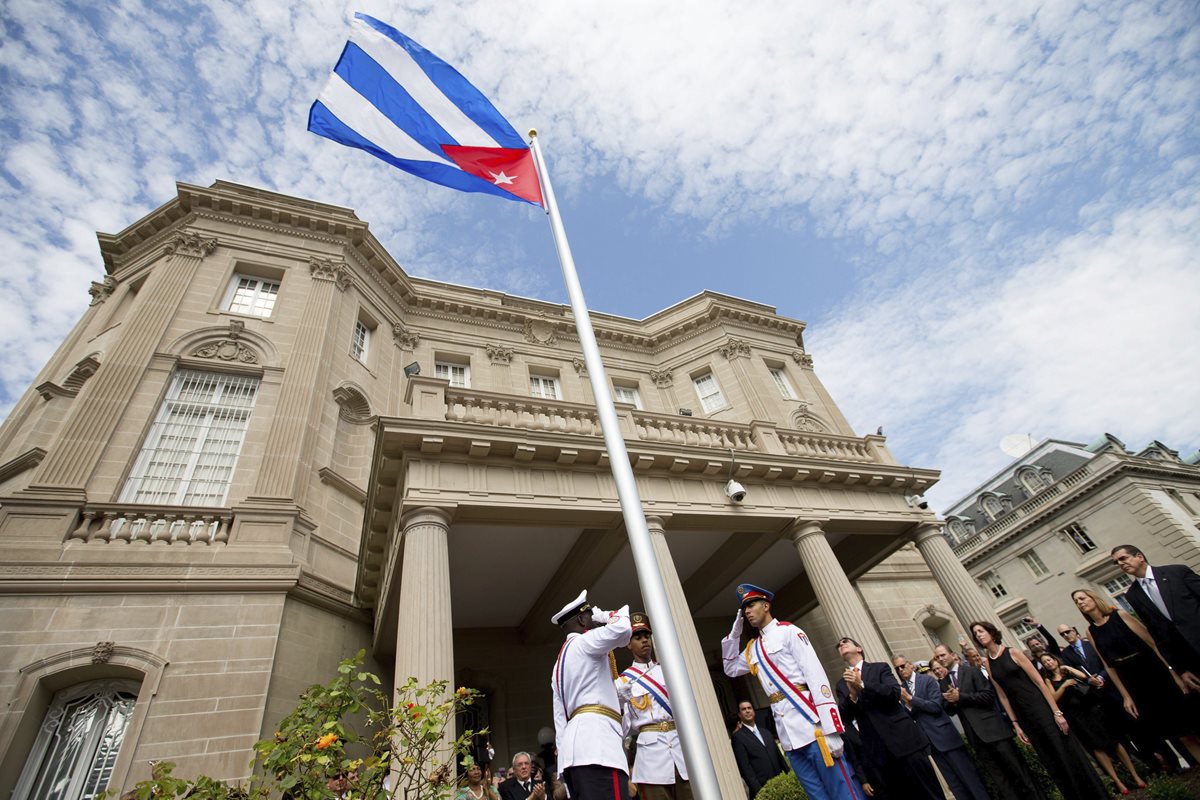 Oficiales cubanos hacen el saludo a la bandera de su país, durante el histórico acto en la cual se izó la bandera cubana en Washington. (Foto Prensa Libre. AFP).