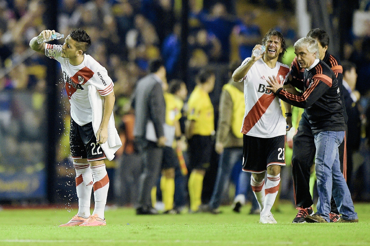 Los jugadores de River Plate, Sebastian Driussi y  Leonardo Ponzio se limpian el rostro luego de que lanzaran gas pimienta desde la tribuna. (Foto Prensa Libre: AFP)