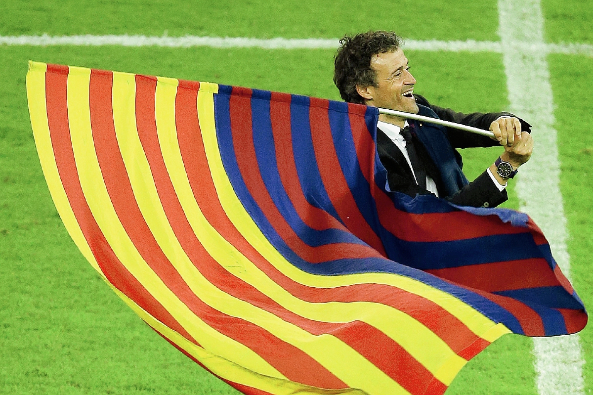 El técnico Luis Enrique ondea la bandera catalana junto a la del FC Barcelona en la celebración del triunfo en la Champions League. (Foto Prensa Libre: AFP)