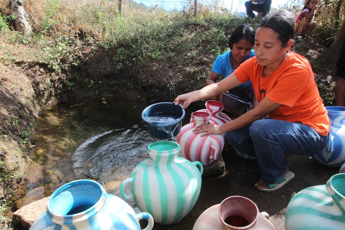 Mujeres que viven en la aldea Volcancito, Palencia, recolectan agua de un pozo natural. (Foto Prensa Libre: Hemeroteca PL)