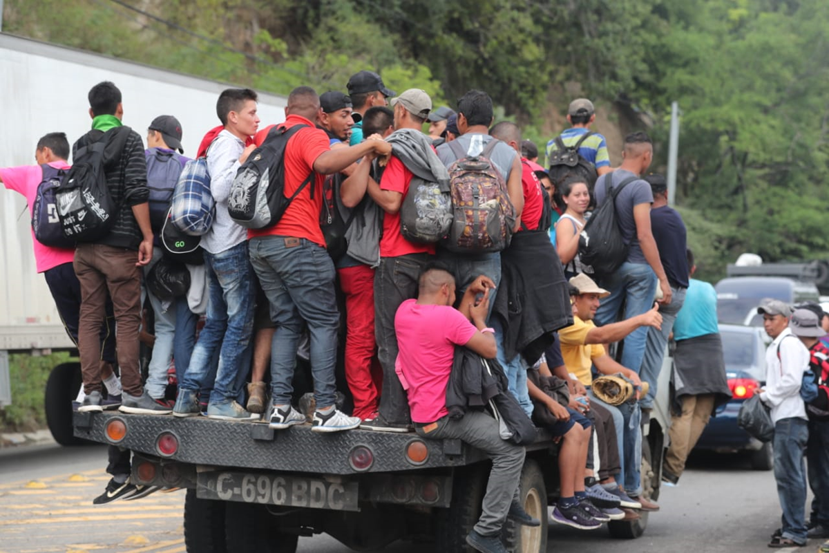 Arriesgando sus vidas, un grupo de migrantes se sube en una plataforma de un tráiler. (Foto Prensa Libre: Érick Ávila)