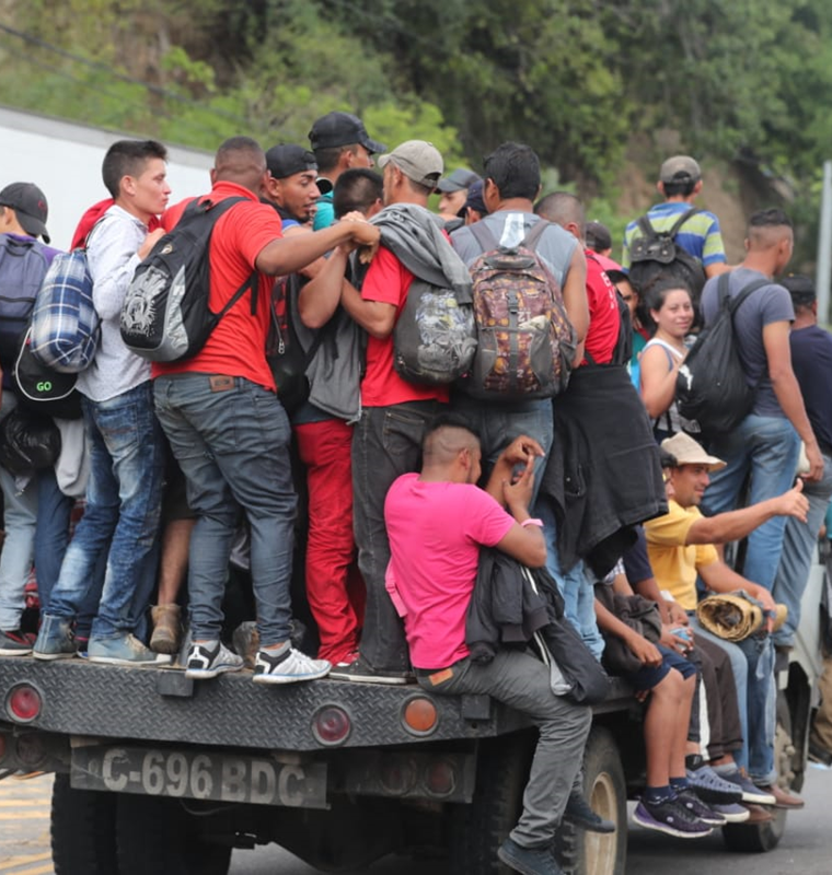 Arriesgando sus vidas, un grupo de migrantes se sube en una plataforma de un tráiler. (Foto Prensa Libre: Érick Ávila)