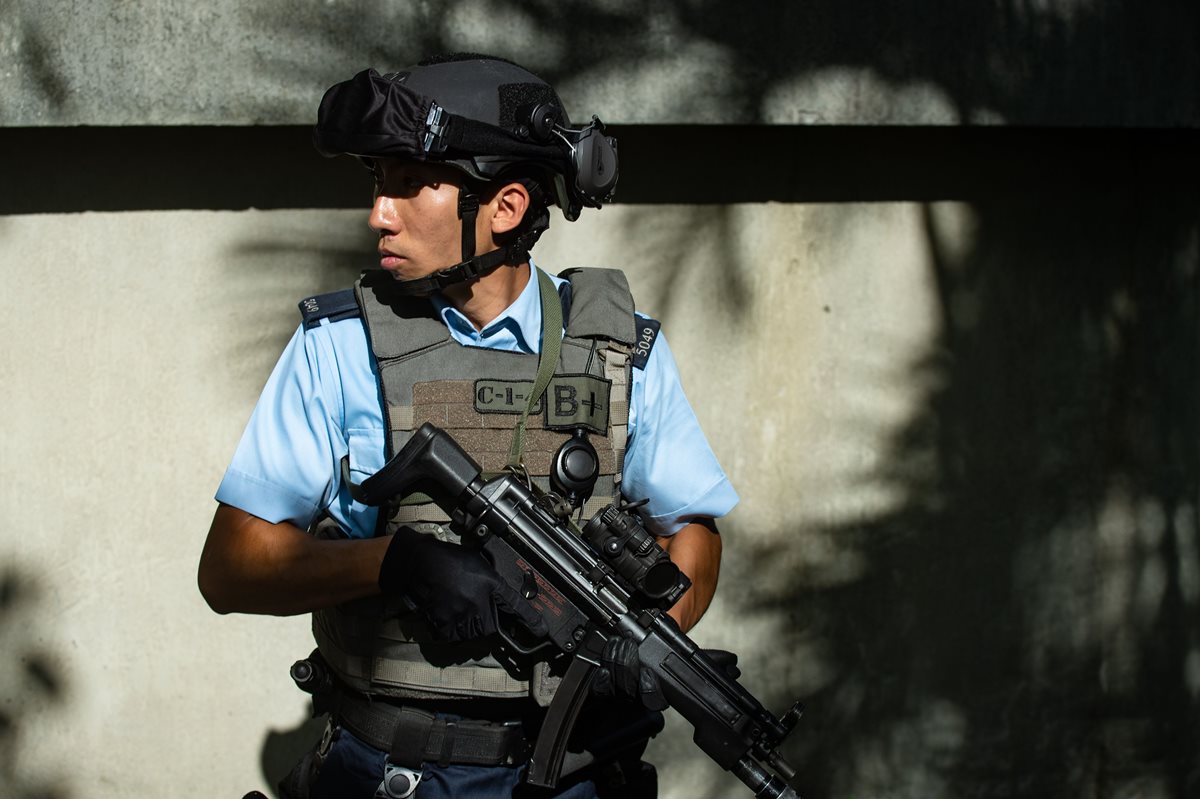 Guarda de la unidad contra el terrorismo resguarda la escena del crimen en Hong Kong. (Foto Prensa Libre: AFP)