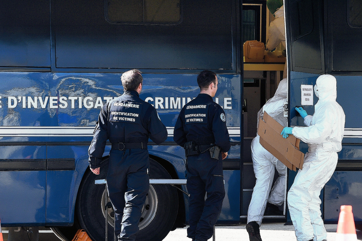 Los agentes de la Policía entran en un laboratorio móvil donde las muestras de ADN de las víctimas del accidente aéreo Germanwings están siendo investigados. (Foto Prensa Libre:AFP).