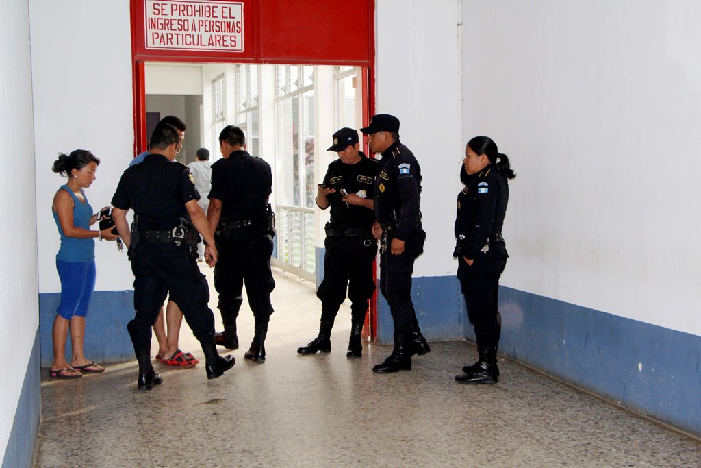 Agentes de la Policía Nacional Civil esperan la llegada de personal del Ministerio Público, en la entrada a la Emergencia del Hospital Nacional de Retalhuleu. (Foto Prensa Libre: Rolando Miranda.