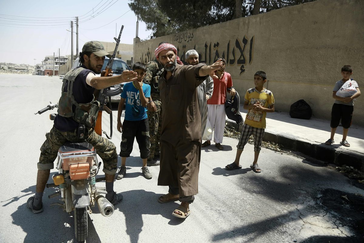 Un soldado indica a un civil sirio dónde ponerse a salvo del extremismo. (Foto Prensa Libre: AFP)