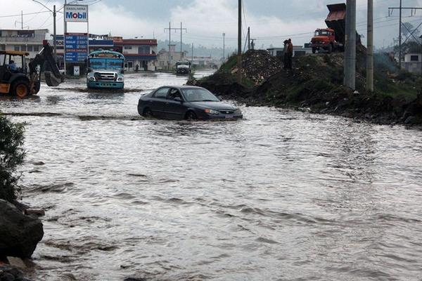 Automovilistas y transportistas afrontan problemas para pasar por la poza que se forma por la lluvia en la ruta a comunidades rurales de Xela. (Foto Prensa Libre: Carlos Ventura)