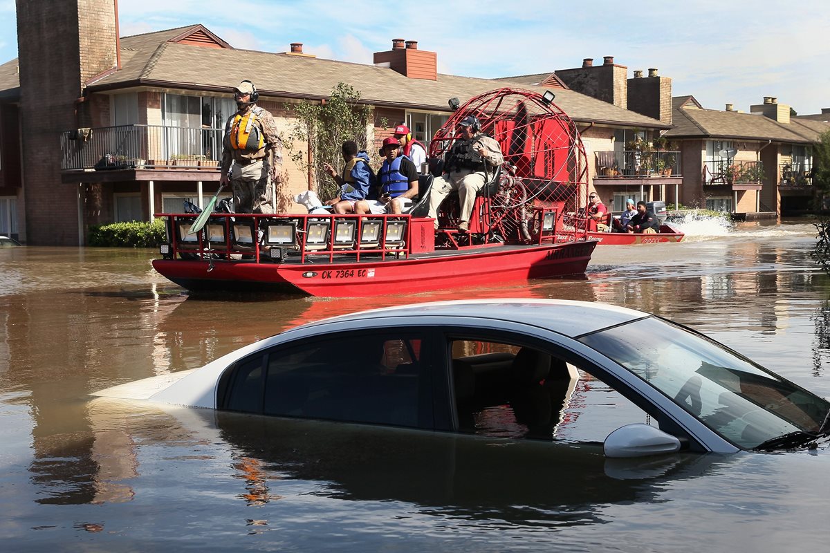 Rescatistas ayudan a los residentes a abndonar un complejo de apartamentos en Houston,Texas.(AFP).