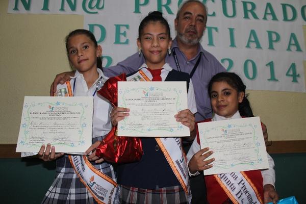 Rosmery Alejandra Mencos -al centro- junto a las dos niñas procuradoras adjuntas muestran el diploma obtenido, las acompaña Darío Flores, auxiliar de la PDH. (Foto Prensa Libre: Óscar González).