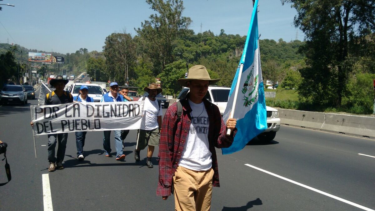 Momento en que los caminantes pasaban por Amatitlán este viernes en la tarde. (Foto Prensa Libre)