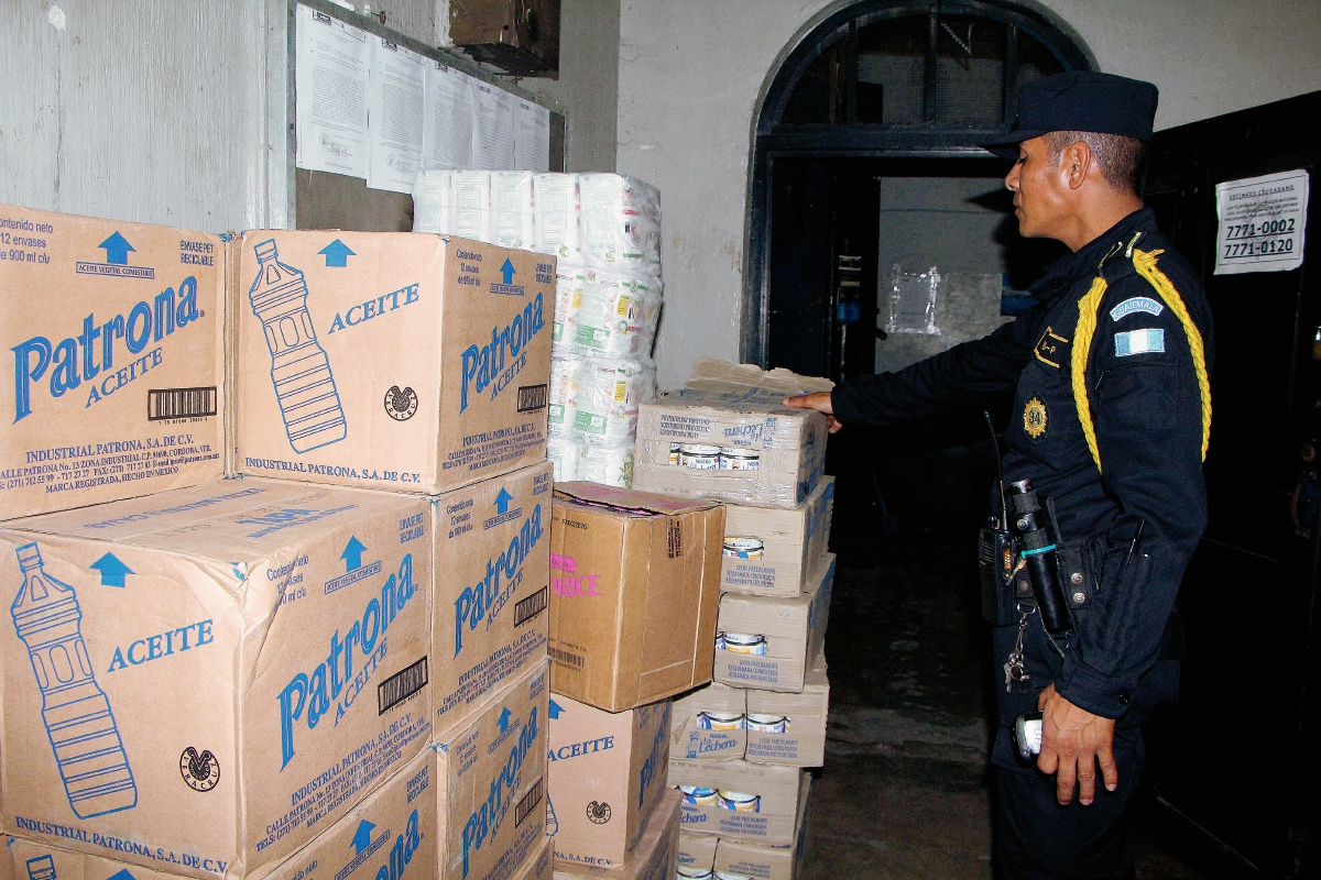 Agente de la PNC observa parte de la mercadería decomisada en Retalhuleu. (Foto Prensa Libre: Rolando Miranda)