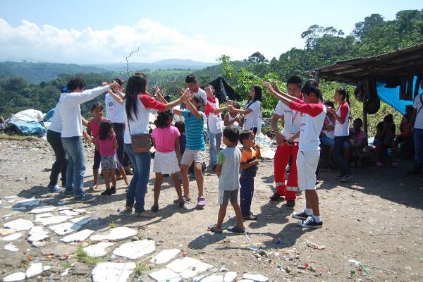 Personal voluntario de la Cruz Roja comparten con niños en el vertedero de desechos de El Quetzal, San Marcos (Foto Prensa Libre: Alexander Coyoy)<br _mce_bogus="1"/>