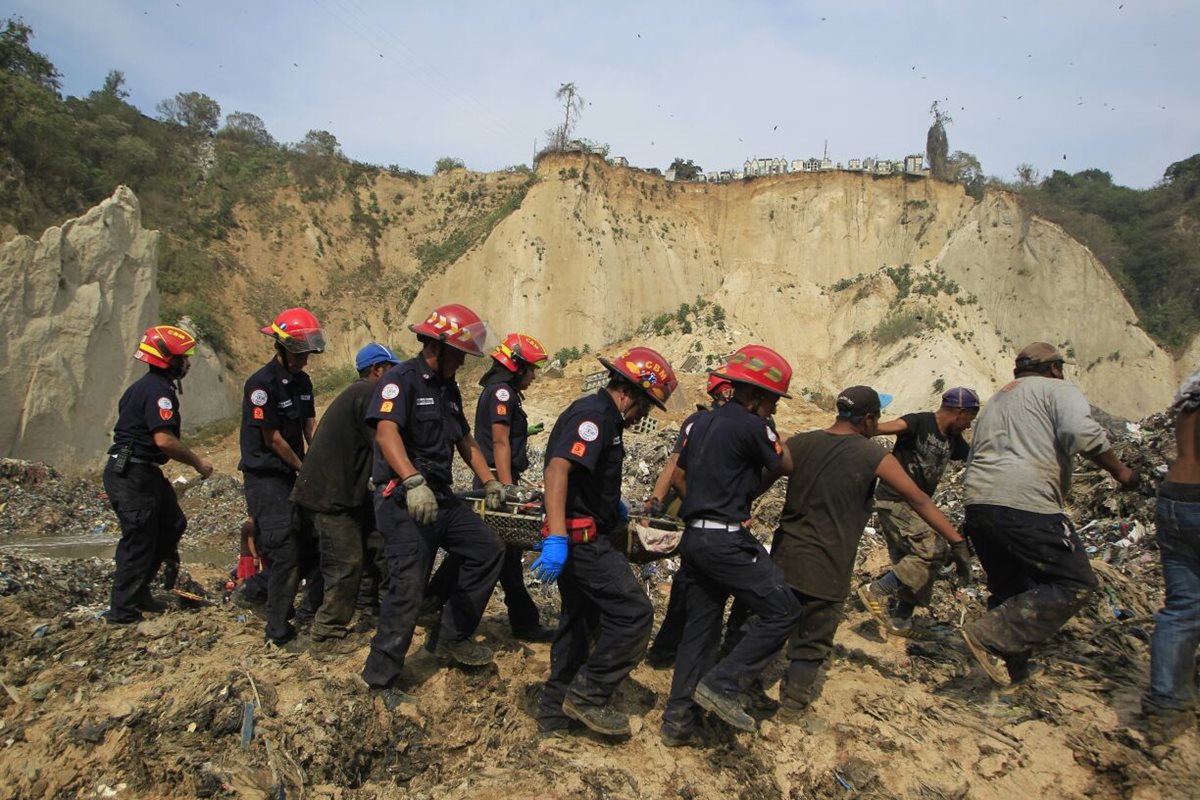 Bomberos Municipales realizan el rescate de una persona que quedó soterrada por el alud. (Foto Prensa Libre: Edwin Bercián)