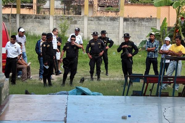 Autoridades y curiosos permanecen junto al Templo Minerva de Jalapa, donde fue ultimado un hombre. (Foto Prensa Libre: Hugo Oliva)<br _mce_bogus="1"/>
