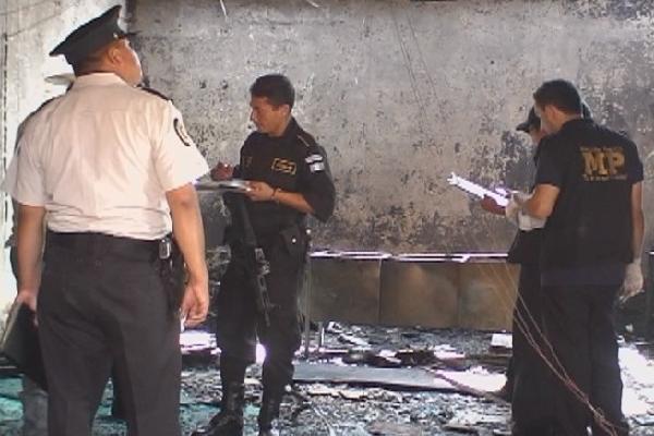 Fiscales del MP y agentes de la PNC inspeccionan  la sede de la coalición UNE-Gana que fue incendiada.