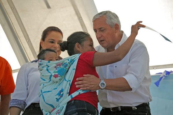 Pérez molina    entrega el bono a una beneficiaria, lo  observa la vicepresidenta Roxana  Baldetti.